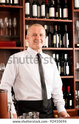 Wine bar waiter happy male in restaurant standing behind counter