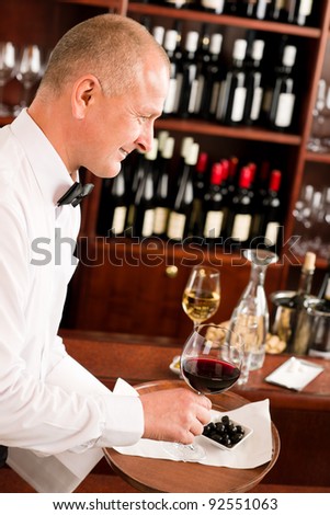 Wine bar waiter mature serving on tray glass olives restaurant