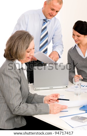 Business team meeting executive senior businesswoman with colleagues pointing report