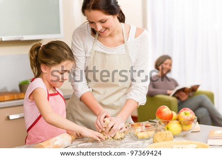 Mother and daughter making apple pie together grandmother check recipe