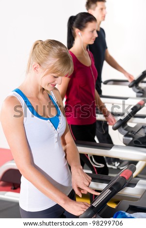 Woman set-up level on running belt at fitness center