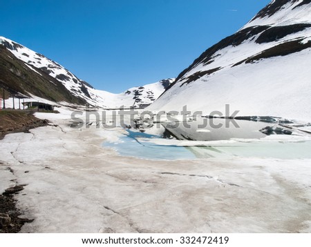 Oberalp pass, Switzerland : Artificial lake ice. The lake is illuminated by the sun during a beautiful day on the day of the Feast of the Ascension