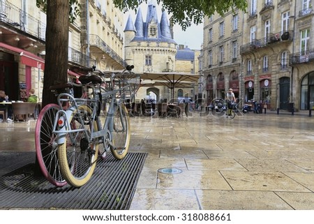Bordeaux, France - September 18 2015, bicycles pause on an old street in Bordeaux after the rain with the view of Gate Porte Cailhau, aquitaine, France