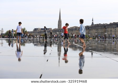 BORDEAUX, FRANCE - 11 October, 2015 : Bordeaux water mirror full of people in one of the hotest summer day, having fun in the water, the pool is the largest water mirror in the world with 3450 sq.m.