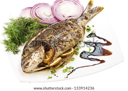 grilled fish (dorado) on the ceramic plate isolated on white