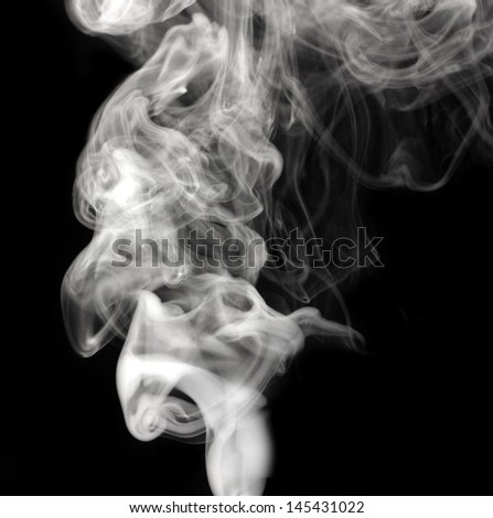Abstract black smoke swirls over the black background