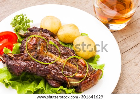 Roasted lamb ribs with rosemary and garlic on ceramic plate