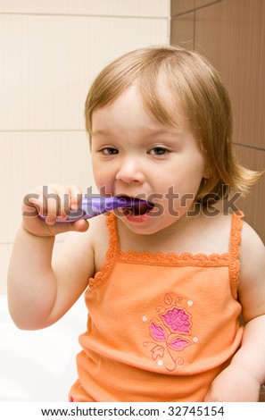sweet toddler baby girl cleaning teeth