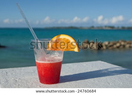 Holiday cocktail resting on balcony overlooking tropical sea