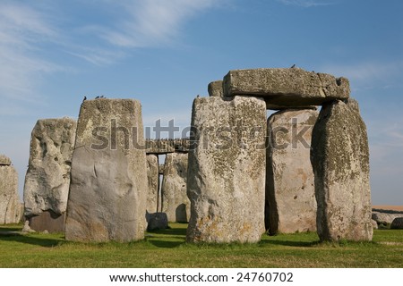 Close-up of the massive circle of stones that make up the world famous landmark and World Heritage Site Stonehenge on Salisbury Plain, Wiltshire, England. Blue sky with white fluffy clouds.