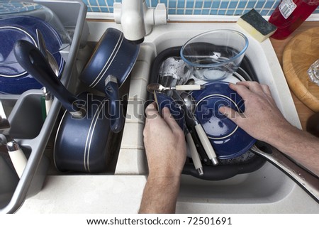 washing up a sink full of dirty dishes
