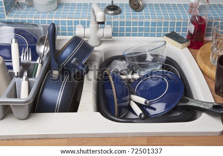 kitchen sink full of dirty dishes for washing up