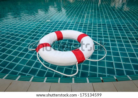 floating white ring on edge of swim pool with waves reflecting in the summer sun