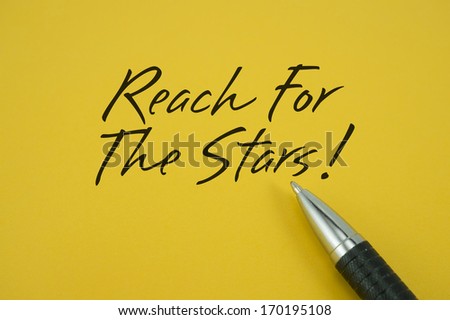 Reach For The Stars note with pen on yellow background