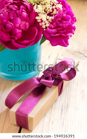 Flowers and present box with ribbon on table. Romantic gift.Valentines\'s day.