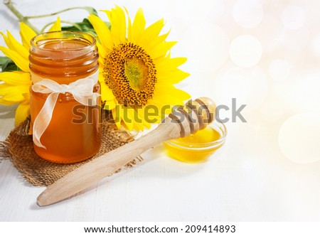 Honey in glass bowl with sunflower. Honey Background.
