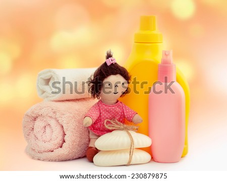 Towels,soap,bottles on pink background. Children washing laundry with toy closeup. Bathroom apparel.