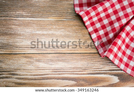 Red picnic cloth on wooden background.Napkin tablecloth on old wood with empty space for text.