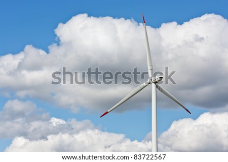 Wind power station against the blue sky with clouds