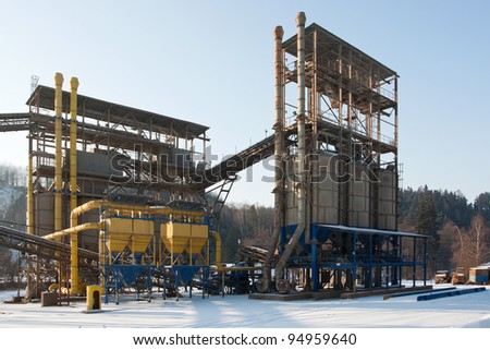 Stone quarry with silos and conveyor belts in winter