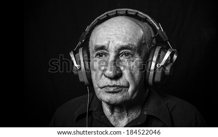 Studio portrait of an old man in headphones