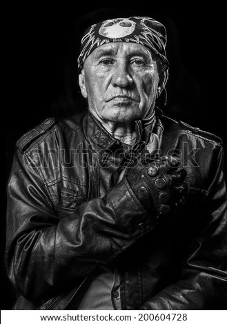 Portrait of an old man biker pointing thumbs up