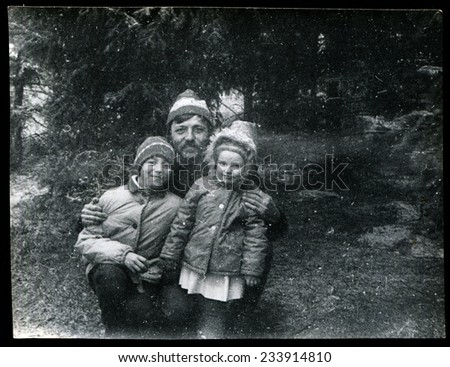 USSR - CIRCA 1970s: An antique photo shows father with two children in the winter forest