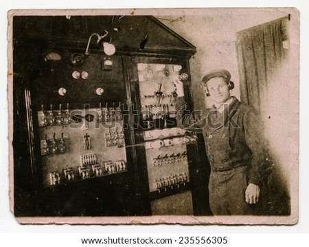 Ussr - CIRCA 1940s: An antique Black & White photo show man near the stand with bulbs