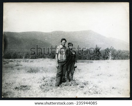 Ussr - CIRCA 1970s: An antique Black & White photo show Two people on a background of mountains