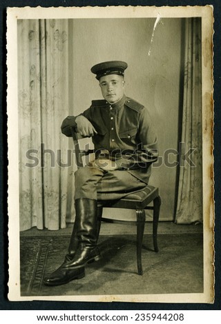 Ussr - CIRCA 1940s: An antique Black & White photo shows soldier sitting on chair