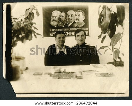 Ussr - CIRCA 1970s: An antique Black & White photo show man and woman on background Marx, Engels, Lenin, Stalin