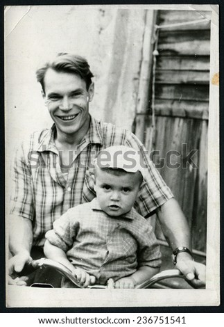 Ussr - CIRCA 1970s: An antique Black & White photo show happy father carries his son on a bicycle