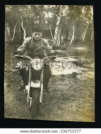 Ussr - CIRCA 1970s: An antique Black & White photo show man riding a motorcycle in the forest