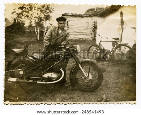 USSR - CIRCA 1970s: An antique Black & White photo show man standing near a motorcycle