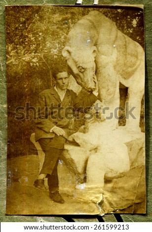 Ussr - CIRCA 1970s: An antique Black & White photo show man near the sculpture bear