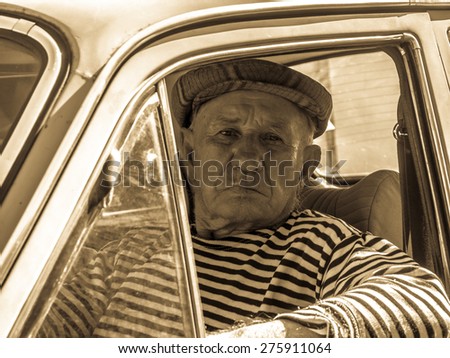 the old man behind the wheel of an old car. Retro stylized photo.