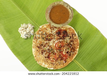 Uttapam, Traditional South Indian Breakfast with sambar and coconut chutney on banana leaf.
