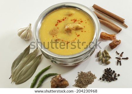 Indian Food- Kadhi with gatte in steel pot on white background.