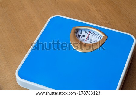 Comfortable scales blue for weighing. Located on the wooden floor.