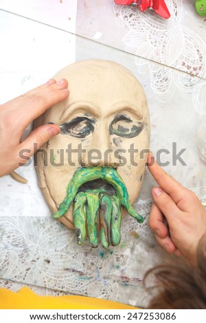 Sculpting craft with plasticine the form of face with moustaches