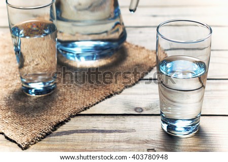 Glasses of water on a wooden table. Selective focus. Shallow DOF