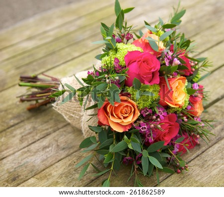 Beautiful and colourful bouquet of flowers over wood table