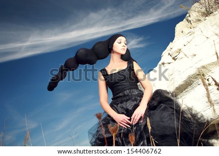 girl with black head-dress under the clouds
