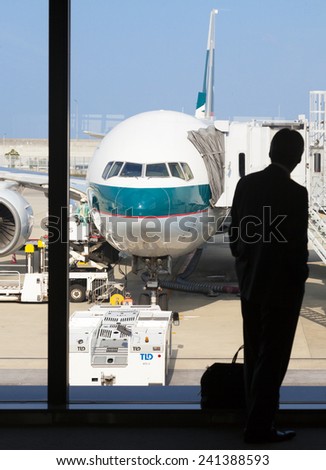 Osaka, Japan - Nov 7: Silhouette of a businessman waiting to board a Cathay Pacific passenger airplane in the Kansai International Airport in Osaka, Japan on Nov 7, 2014.