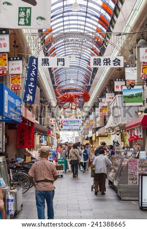 Osaka, Japan - Oct 26: People shopping in the Kuromon Market in Osaka, Japan on Oct 26, 2014.  The market has been called 'Osaka's Kitchen' as many chefs in Osaka come here to get the ingredients.