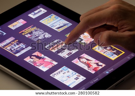 Hong Kong, China - August 7, 2011: Reading magazines on an iPad running the Zinio app. Zinio is a publishing technology and services company, which provides sales and distribution of printed material