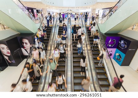 Hong Kong, China - June 2, 2015: People riding on escalators in a busy shopping mall in Hong Kong