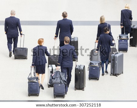 Hong Kong, China - June 12, 2015: Group of cabin crew walking at the Hong Kong International Airport, carrying their luggage