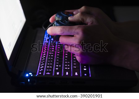 Playing computer game on laptop with joypad