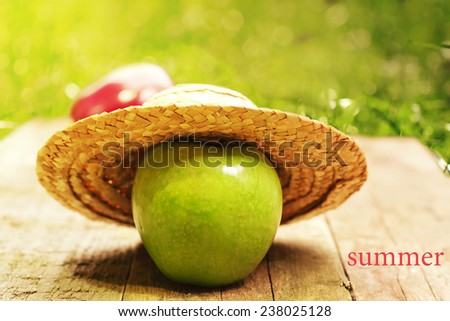 apple  straw hat summer wooden background is an old rustic retro vintage organic product selective soft focus toned photo